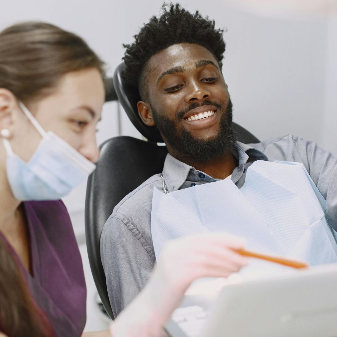 woman dentist speaking to male patient
